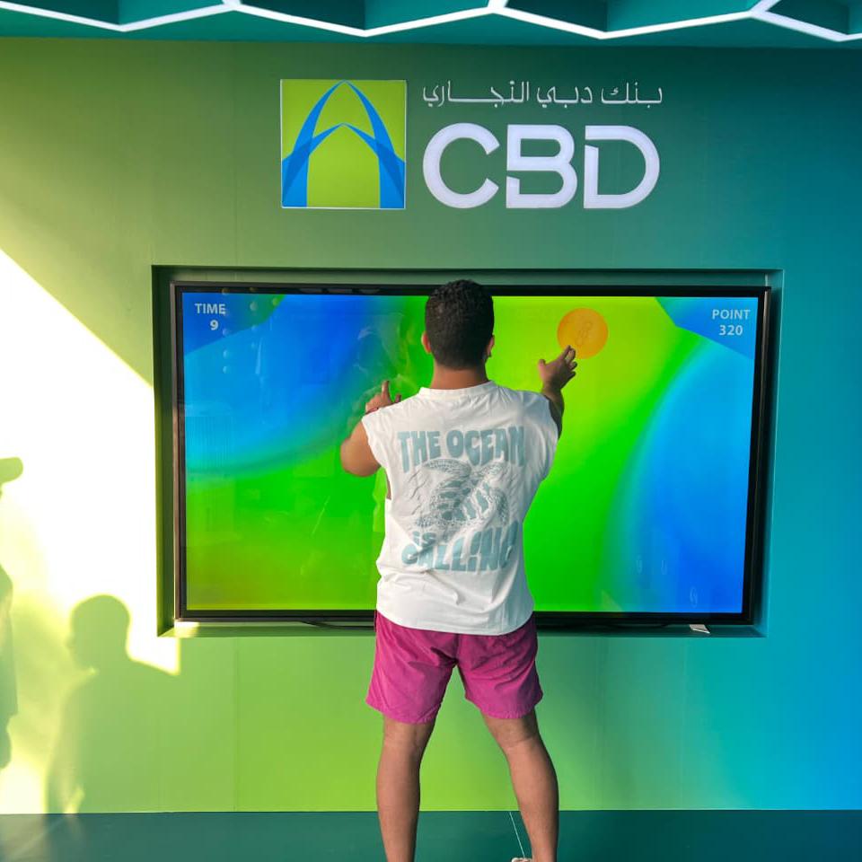 Interactive multi-level touch screen game rental at Dubai 30x30 event, showing guests engaged in a gamified fitness and financial literacy challenge.